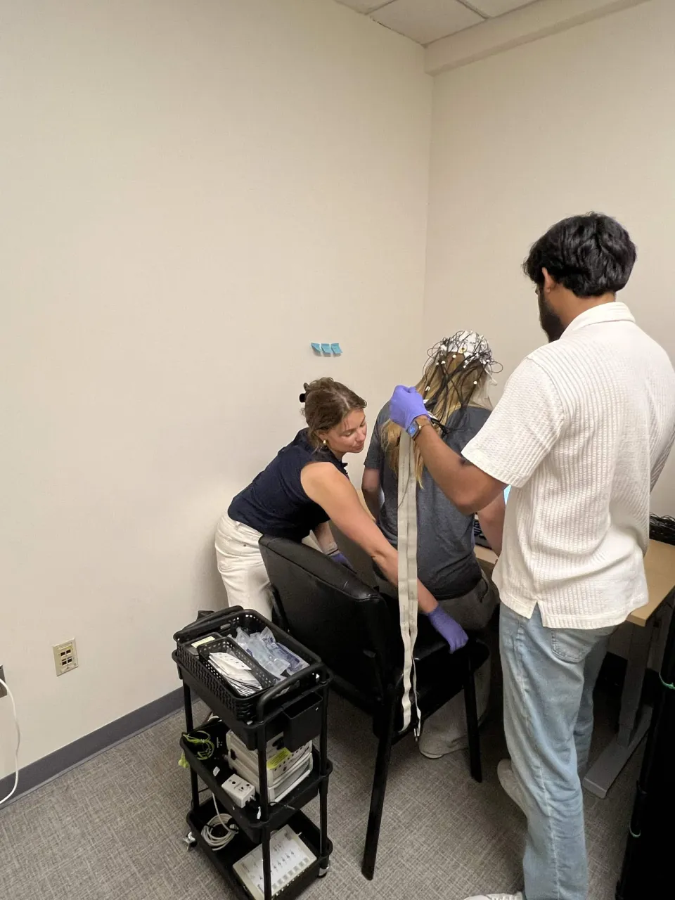Researchers preparing an EEG cap for a recording session